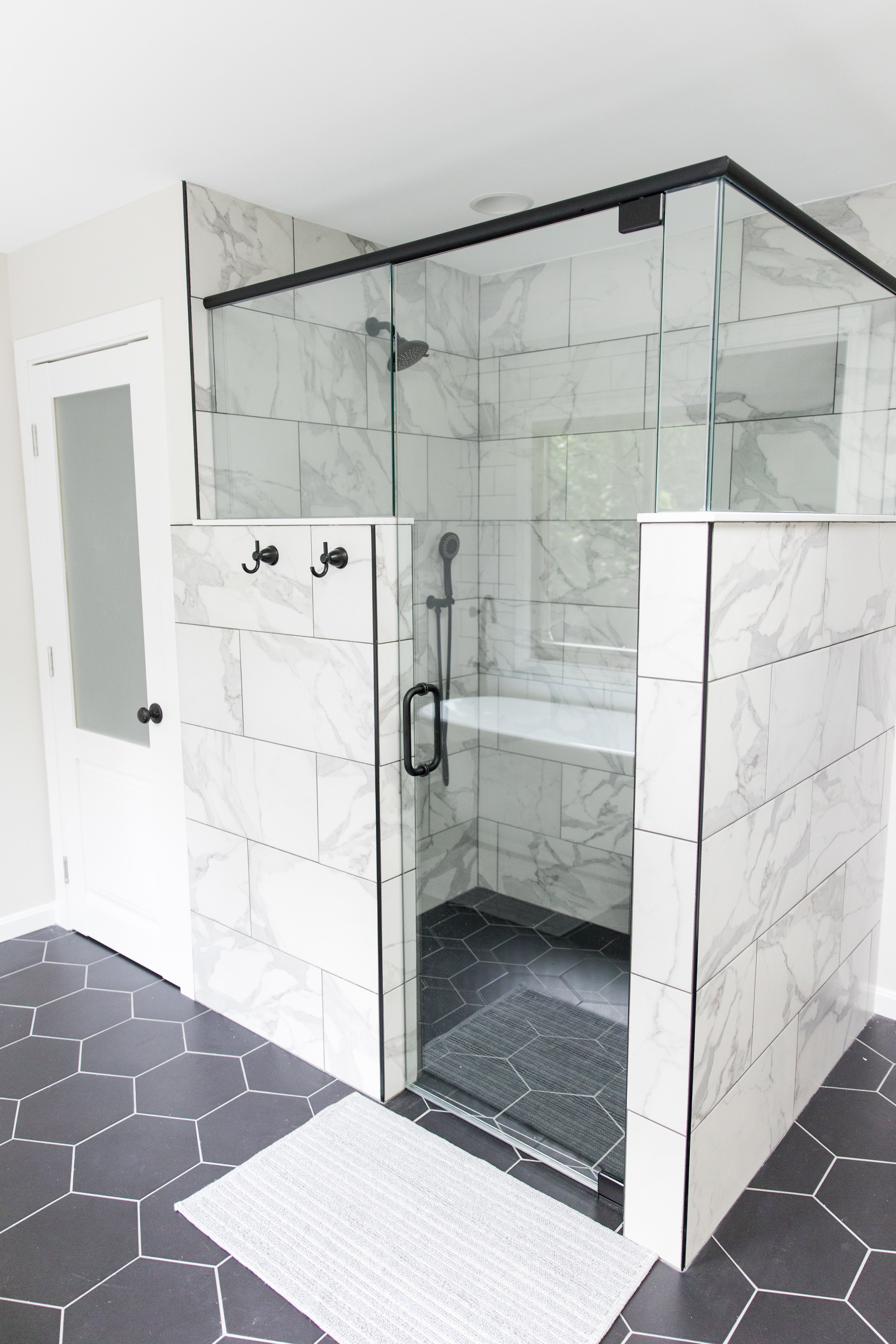 Wood vanity, subway tile & black hex master bath, view 5 of 9
