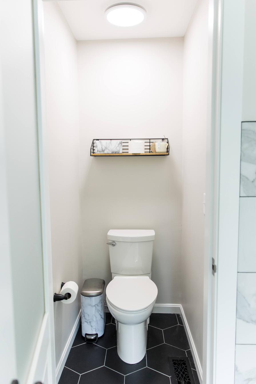 Wood vanity, subway tile & black hex master bath, view 7 of 9