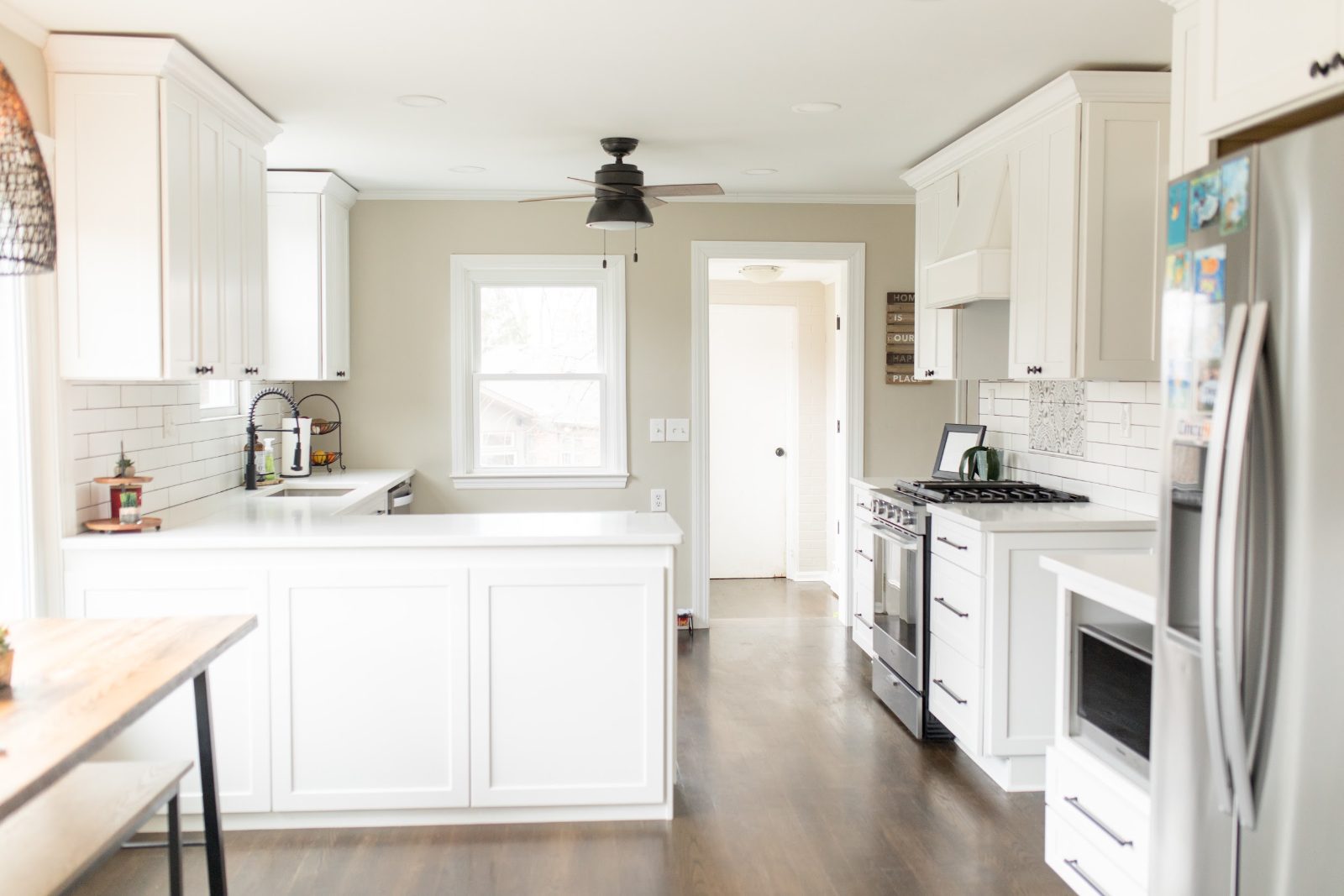 Open white kitchen with island seating and stainless appliances