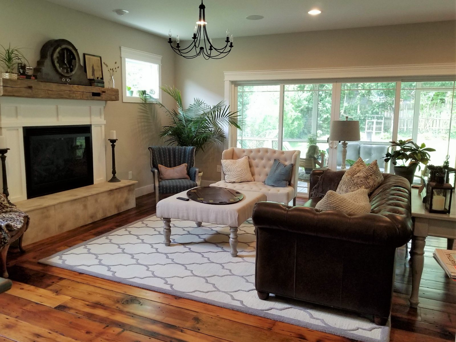 Maple Ave. living room with a stone fireplace, leather sofa and patterned rug