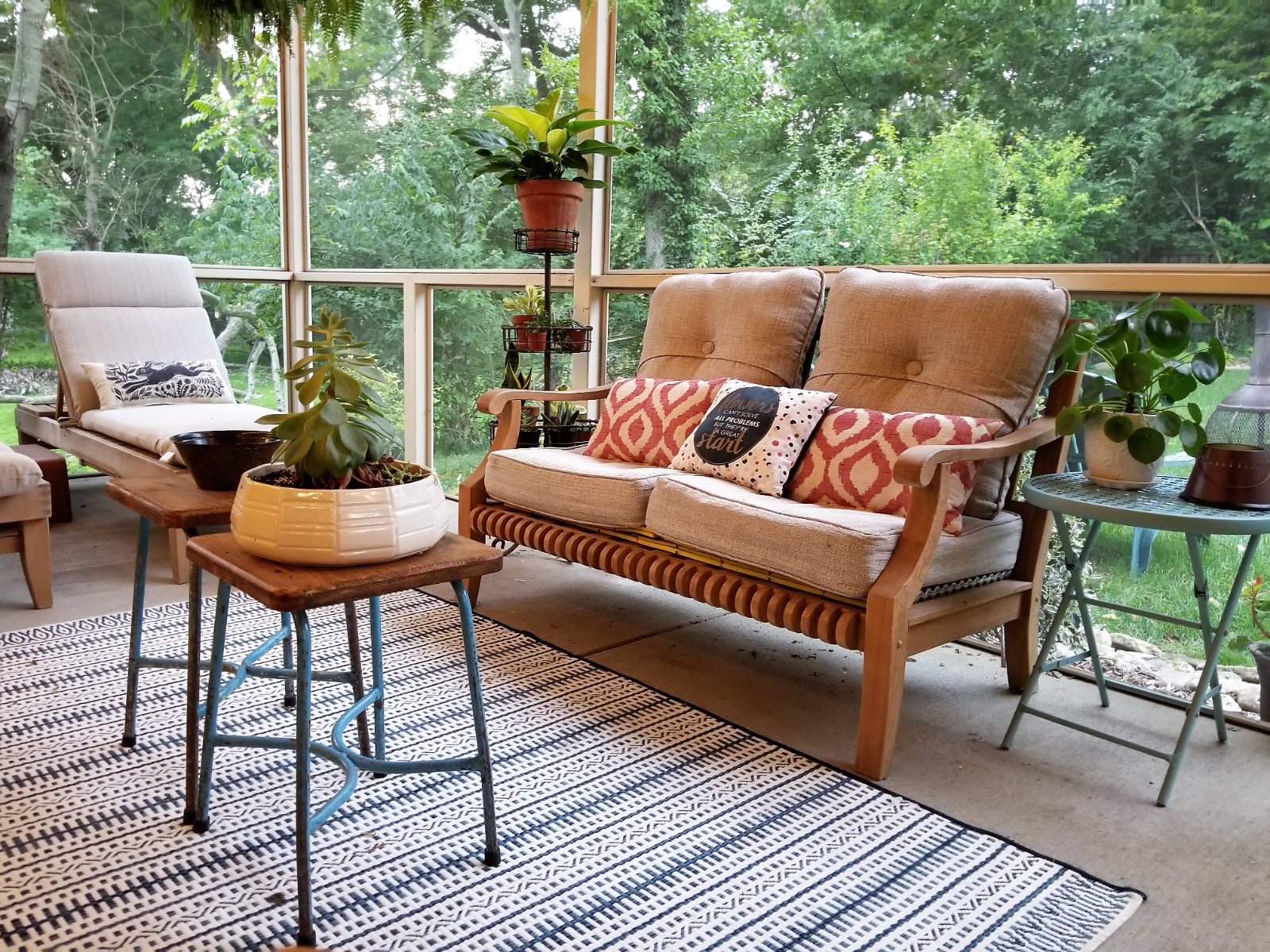 Maple Ave. screened porch with a teak sofa, patterned cushions and hanging ferns